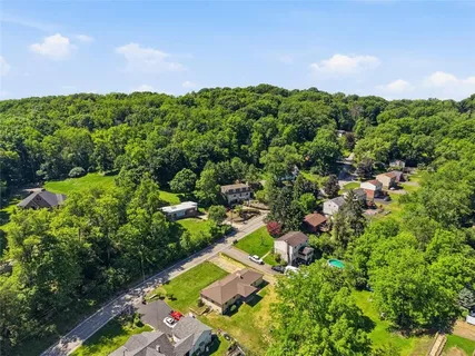 an aerial view of residential houses with outdoor space and trees