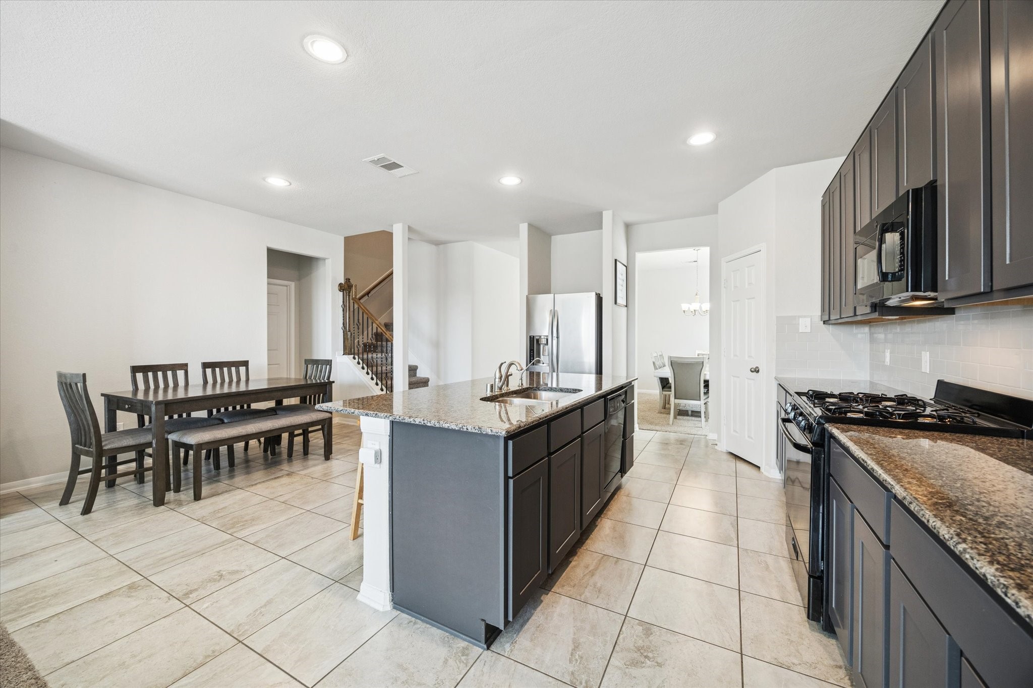 322 Upland Grv Trail Rosharon, TX 77583 - Photo 11 of 36 a kitchen with stainless steel appliances granite countertop a stove a sink a microwave and a refrigerator