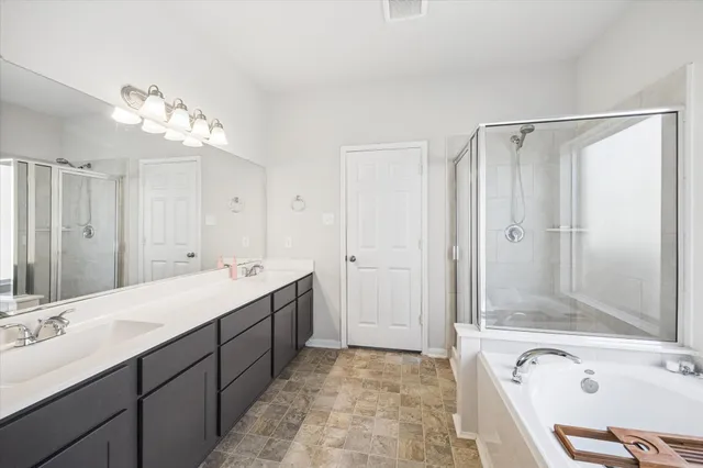 a bathroom with a tub sink and mirror