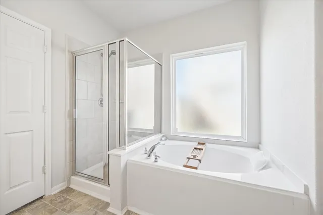 a bathroom with a tub a sink and a window