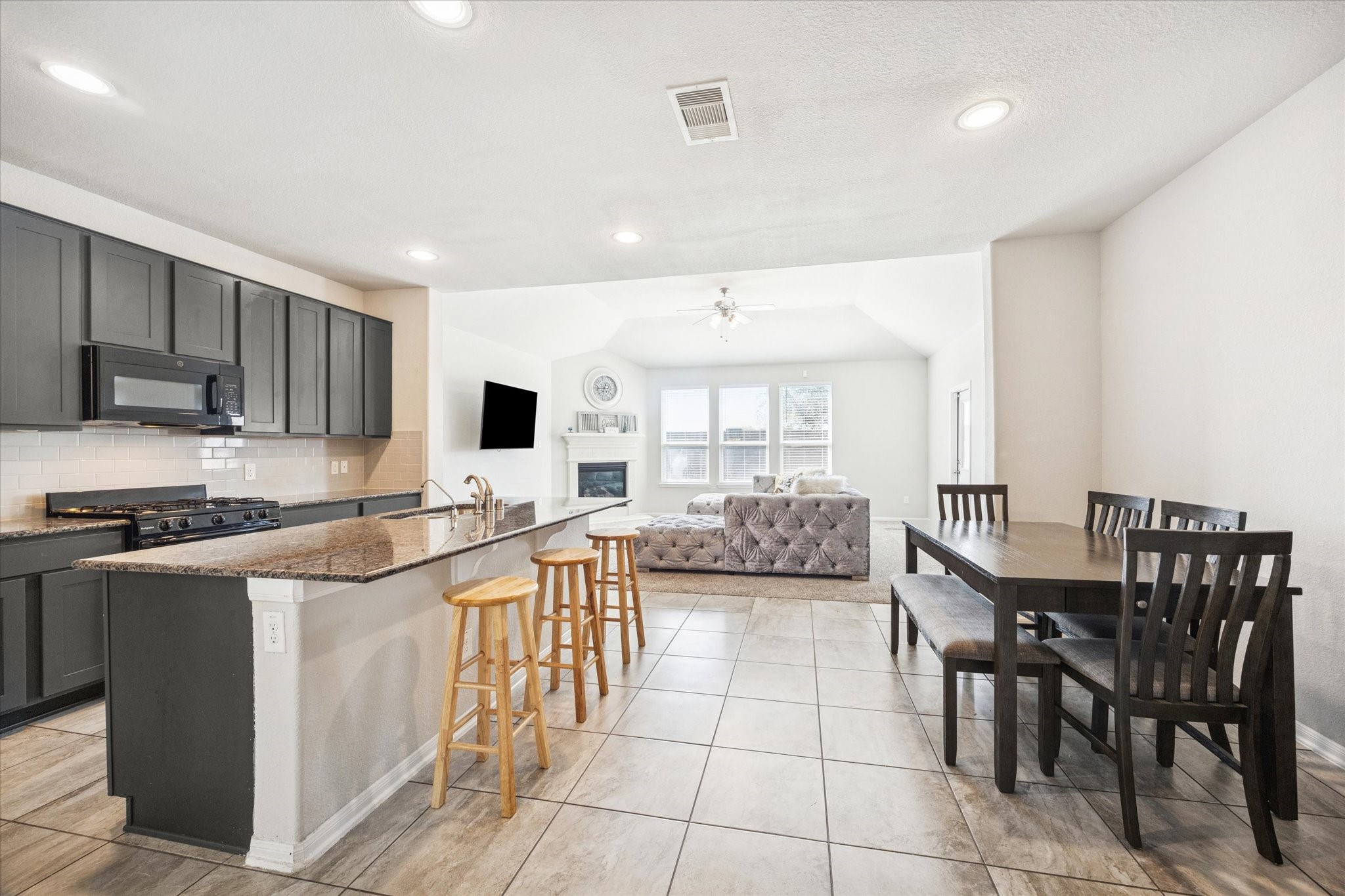 322 Upland Grv Trail Rosharon, TX 77583 - Photo 7 of 36 a kitchen with stainless steel appliances granite countertop a stove top oven a sink a dining table and chairs