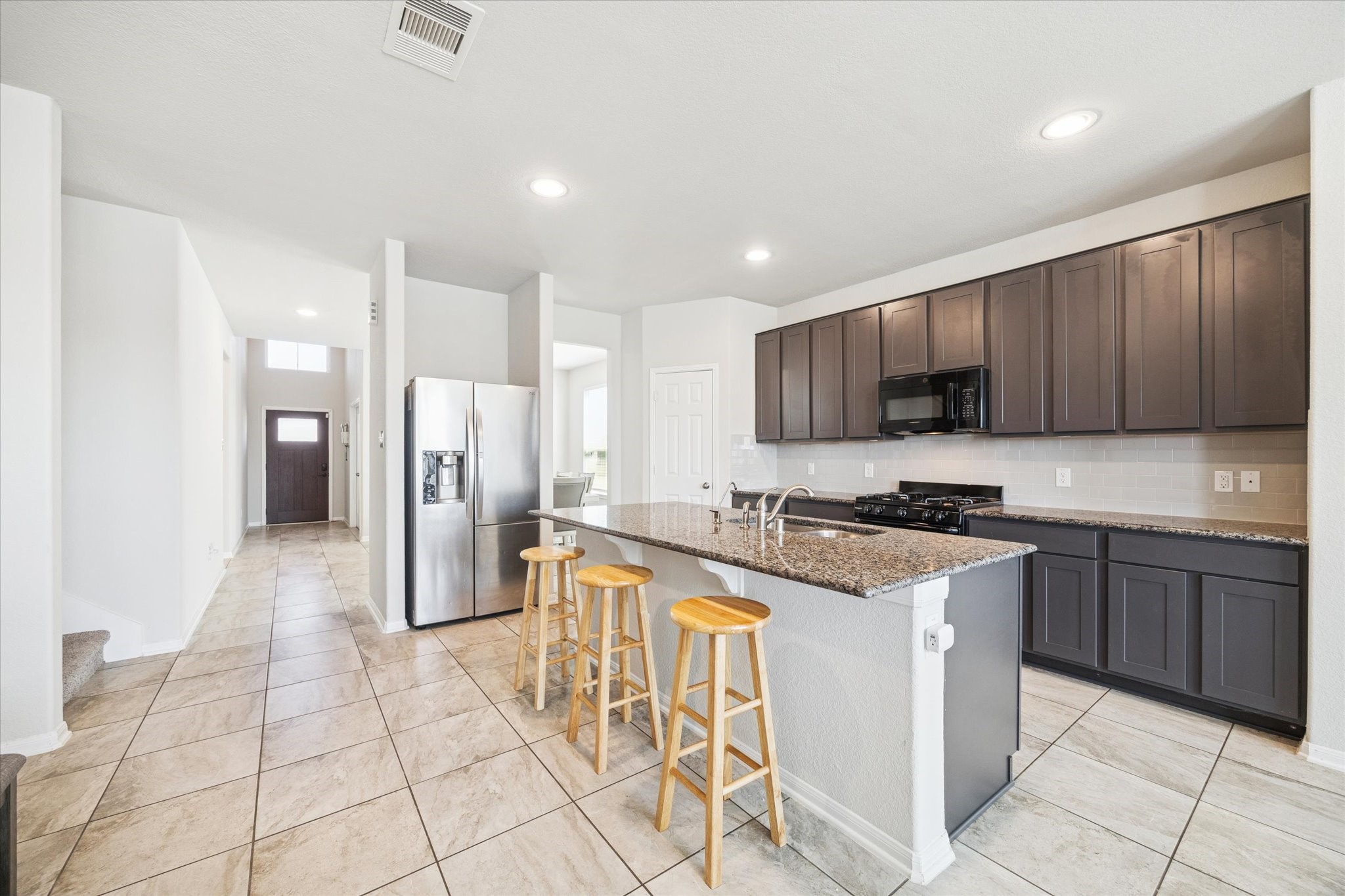 322 Upland Grv Trail Rosharon, TX 77583 - Photo 8 of 36 a kitchen with granite countertop a stove a sink dishwasher a refrigerator and cabinets with wooden floor