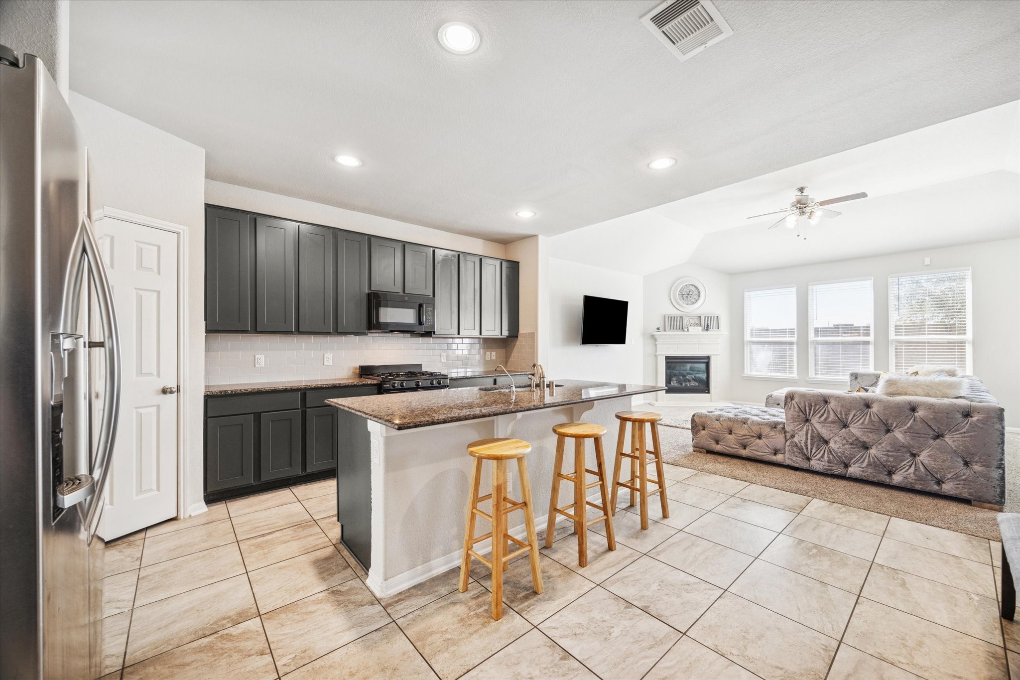322 Upland Grv Trail Rosharon, TX 77583 - Photo 9 of 36 a kitchen with stainless steel appliances granite countertop a stove top oven a sink a dining table and chairs