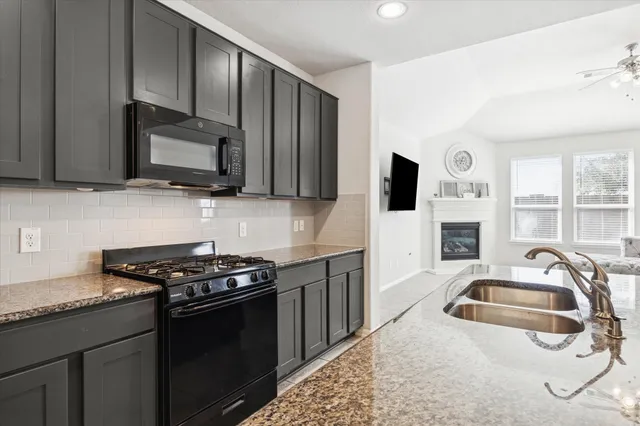 a kitchen that has a sink and a stove top oven