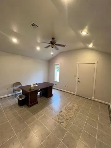 a living room with patio furniture and a ceiling fan