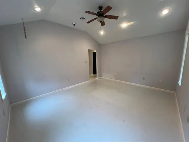 an empty room with a ceiling fan and window