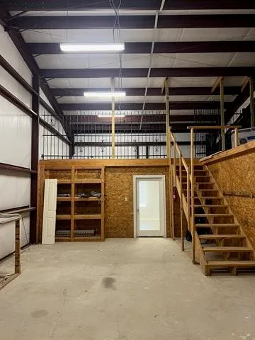 a view of an empty room with furniture and windows
