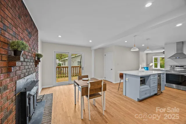 a living room with furniture a wooden floor and kitchen view
