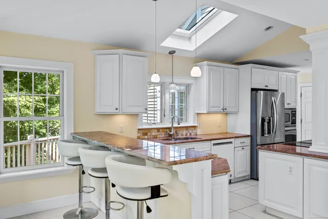 a kitchen with refrigerator a sink and chairs