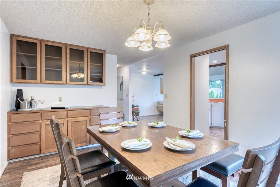 12216 Southeast 258 Place Kent, WA 98030 - Photo 11 of 40 a view of a dining room with furniture a chandelier and wooden floor