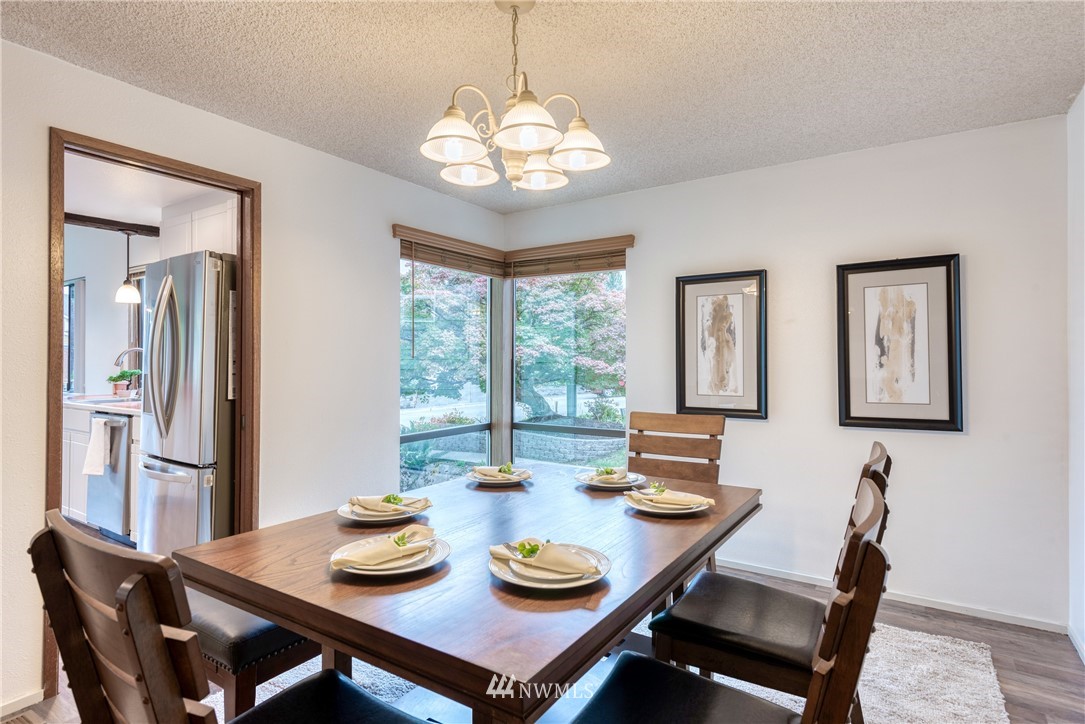 12216 Southeast 258 Place Kent, WA 98030 - Photo 12 of 40 a view of a dining room with furniture a chandelier and large windows