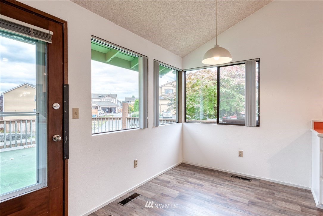 12216 Southeast 258 Place Kent, WA 98030 - Photo 16 of 40 a view of an empty room with wooden floor and a window