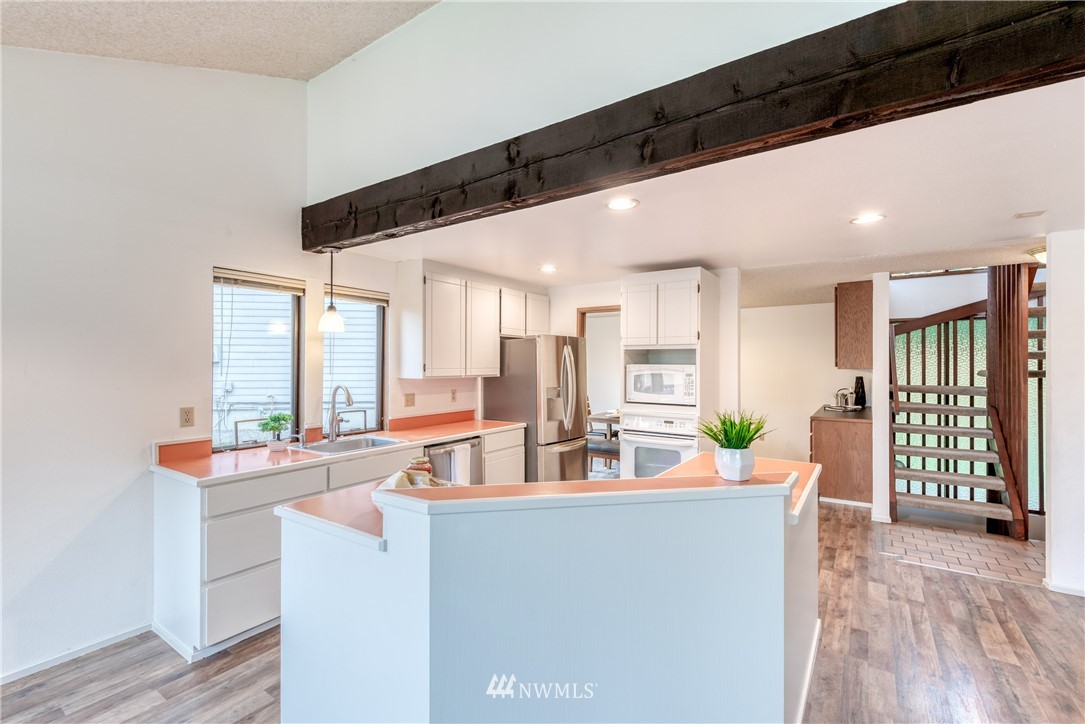 12216 Southeast 258 Place Kent, WA 98030 - Photo 22 of 40 a room with stainless steel appliances kitchen island granite countertop a refrigerator a sink and a stove with wooden floor