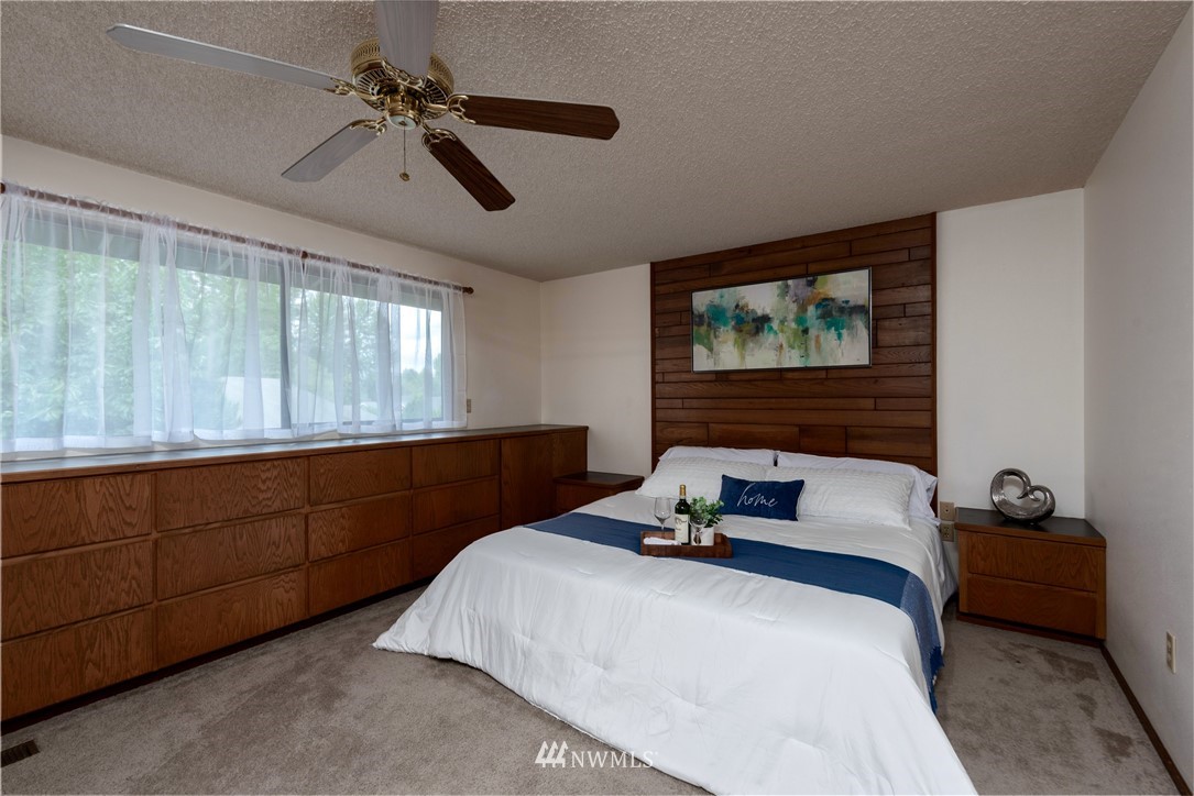 12216 Southeast 258 Place Kent, WA 98030 - Photo 24 of 40 a bedroom with a bed a window and a chandelier