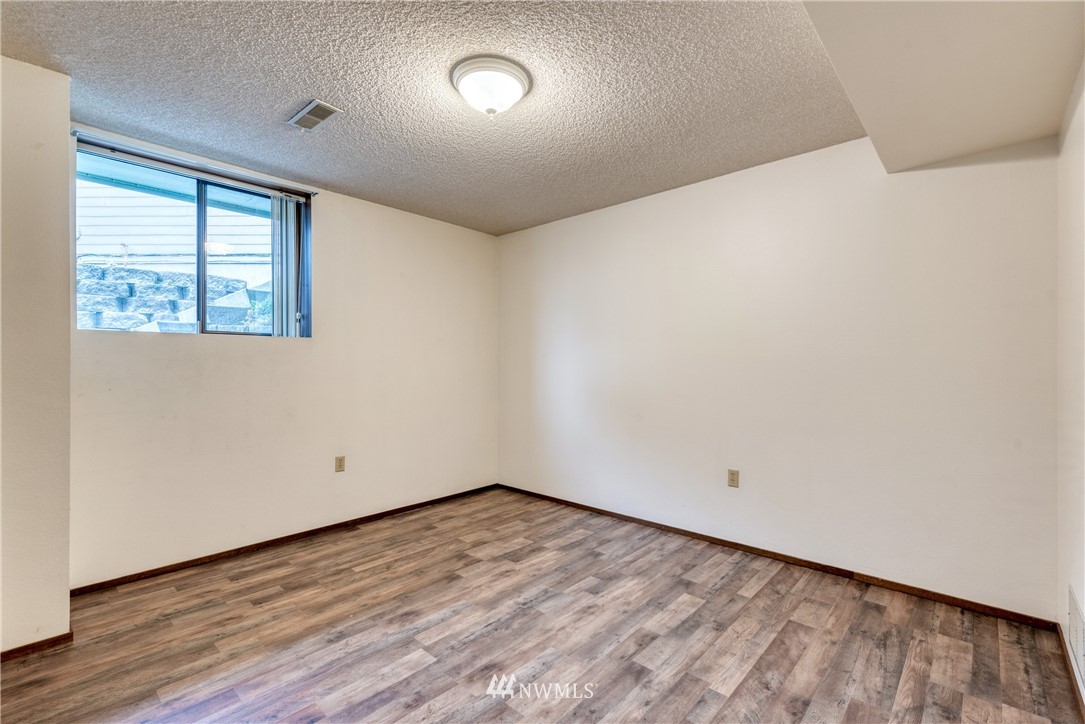 12216 Southeast 258 Place Kent, WA 98030 - Photo 36 of 40 an empty room with wooden floor and windows