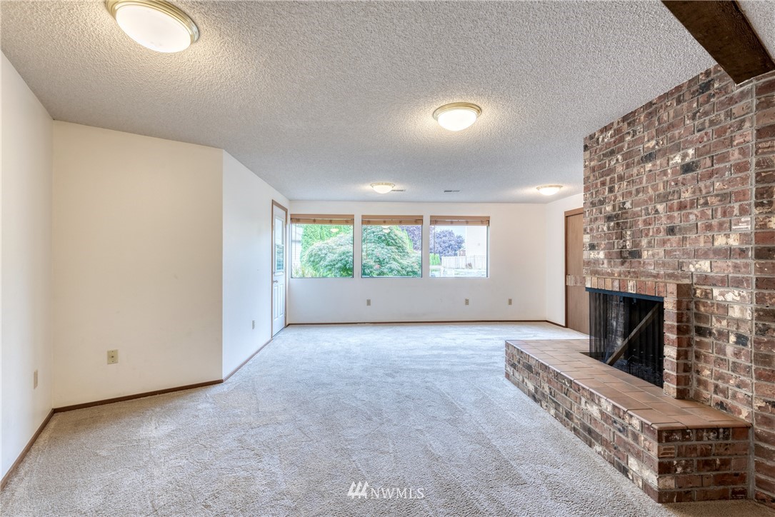 12216 Southeast 258 Place Kent, WA 98030 - Photo 37 of 40 an empty room with fireplace and windows