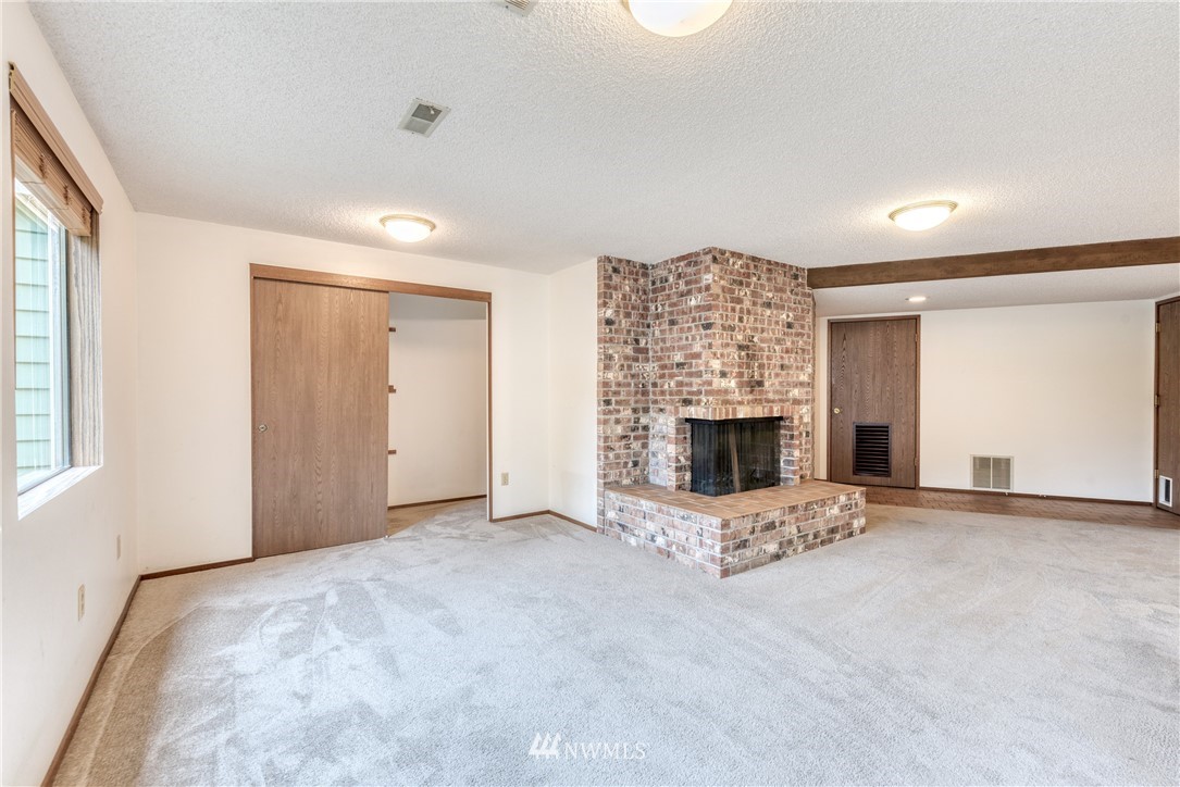 12216 Southeast 258 Place Kent, WA 98030 - Photo 38 of 40 a view of an empty room with a fireplace and a window