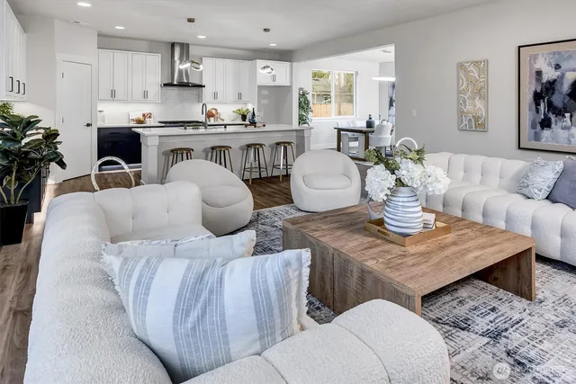a living room with furniture kitchen view and a window