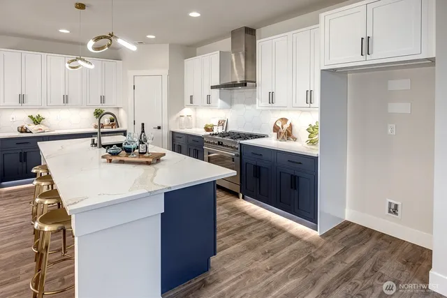 a kitchen with a sink a stove a refrigerator and white cabinets