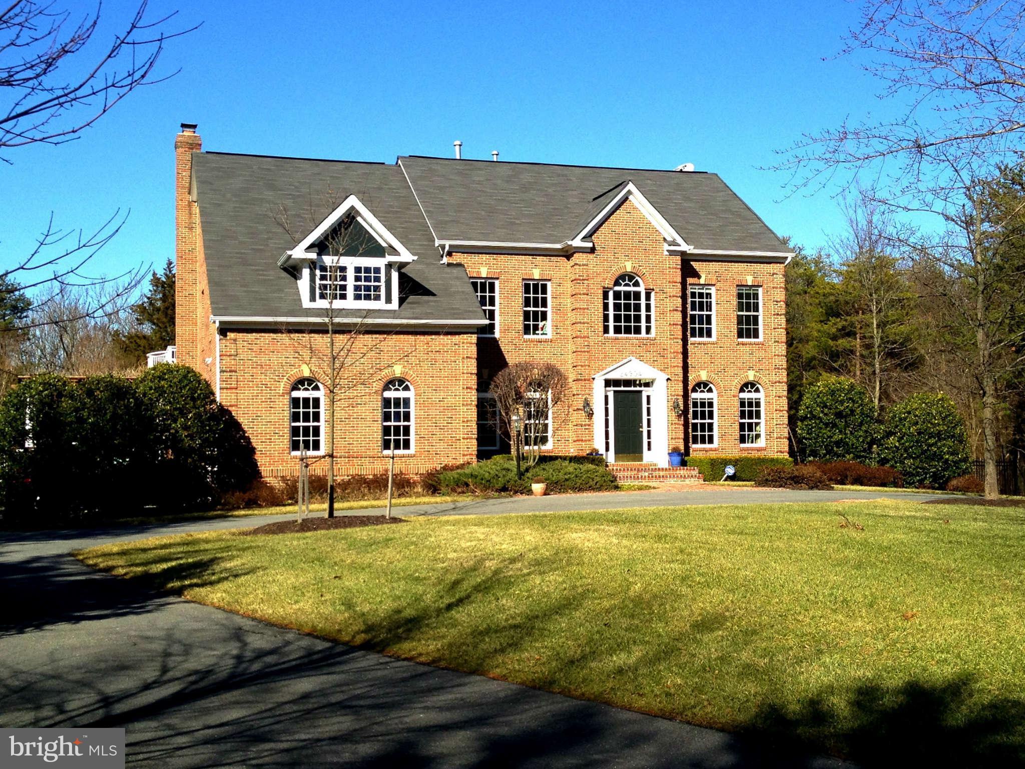 24904 Frederick Road Clarksburg, MD 20871 - Photo 1 of 30 a view of a white house with a big yard and large trees