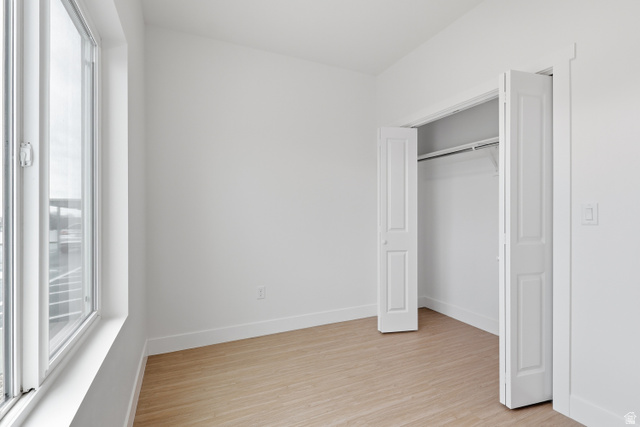 2085 North Main Street, Unit 301 Sunset, UT 84015 - Photo 7 of 20 Bedroom with light wood-style floors and a closet