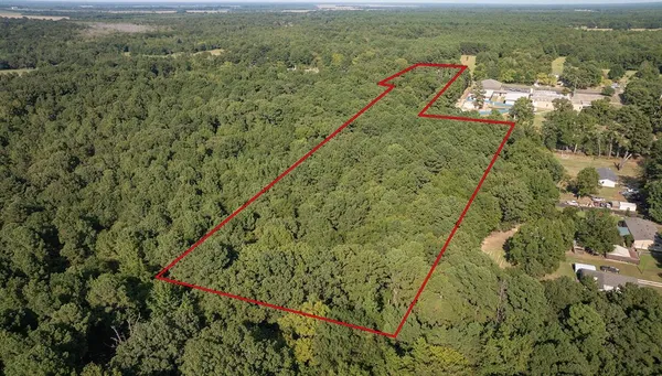 an aerial view of residential house with outdoor space and trees all around