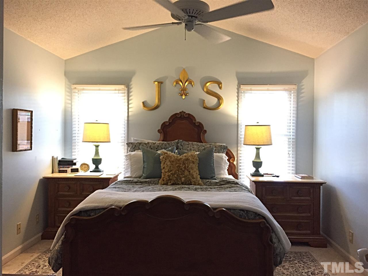 4114 Olde Coach Road Durham, NC 27707 - Photo 8 of 16 a bedroom with a bed and a chandelier