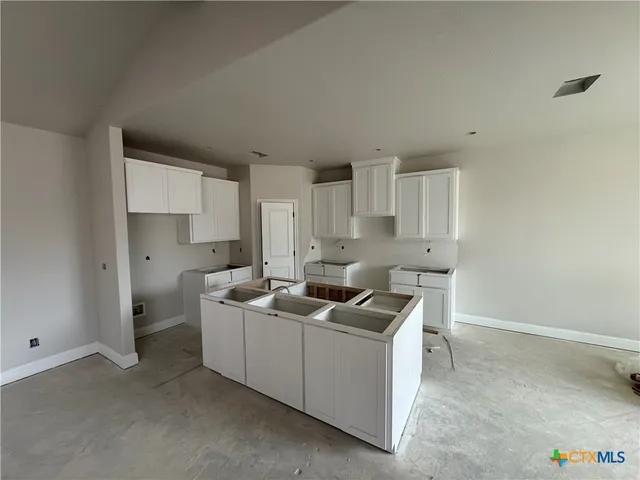 a kitchen with cabinets and a stove top oven