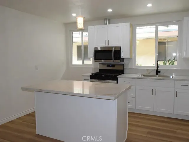 a kitchen with appliances a sink and a window