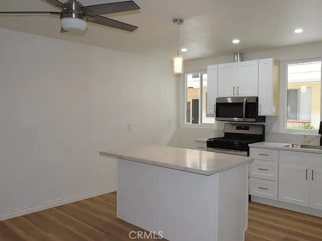 a kitchen with granite countertop a sink cabinets and stainless steel appliances