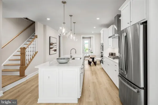 a kitchen with stainless steel appliances granite countertop a refrigerator a oven a sink and a stove