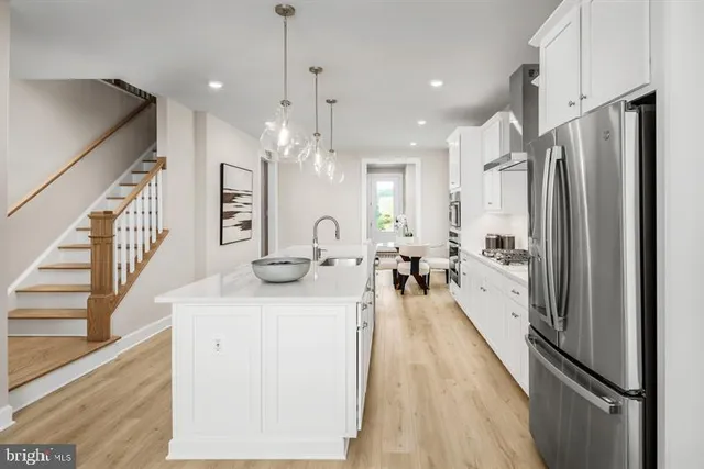 a kitchen with stainless steel appliances granite countertop a refrigerator a oven a sink and a stove