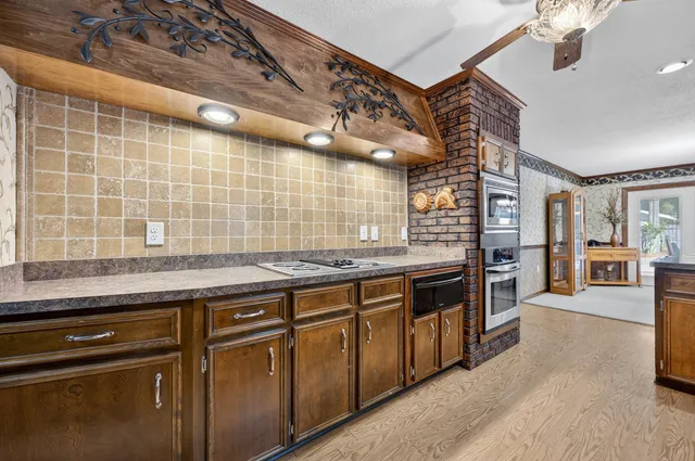 a spacious bedroom with a bed a dresser and a chandelier
