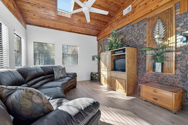 a view of a patio with table and chairs potted plants and floor to ceiling window