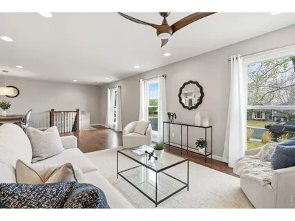 a living room with furniture a window and a fan