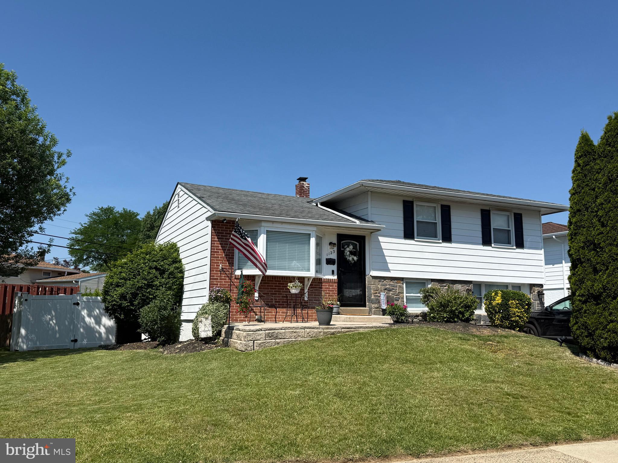 1123 Wynnbrook Road Secane, PA 19018 - Photo 1 of 14 a front view of a house with a garden and trees