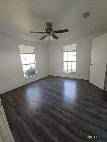 an empty room with wooden floor and window