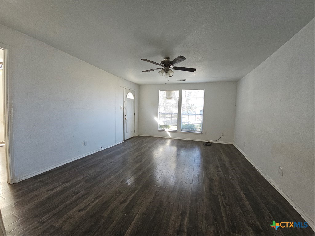 1001 South 29th Street Temple, TX 76504 - Photo 7 of 14 an empty room with wooden floor and windows