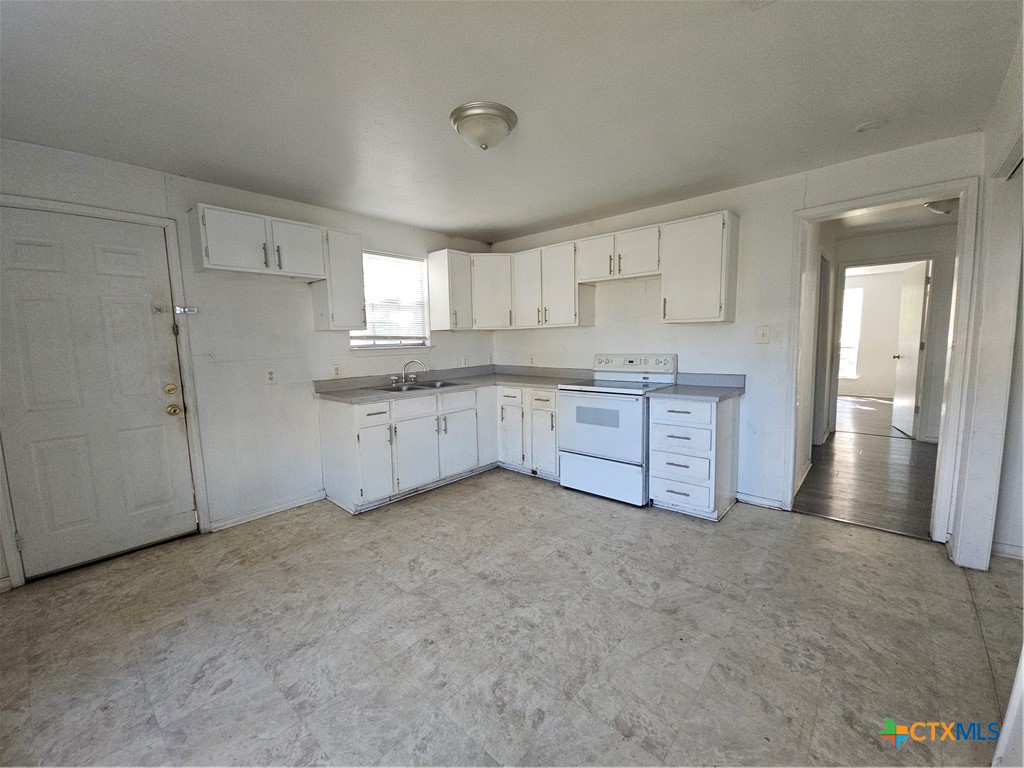 1001 South 29th Street Temple, TX 76504 - Photo 9 of 14 a large white kitchen with a sink and refrigerator