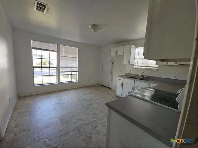 a kitchen with a sink stove and cabinets