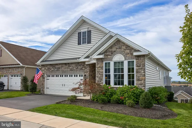 a view of a house with a yard and potted plants