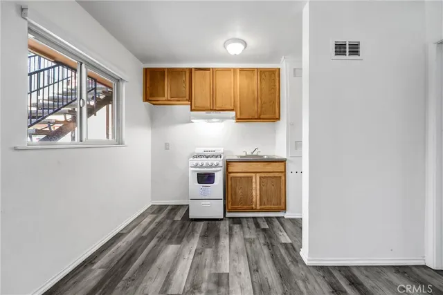 a view of a kitchen with a sink cabinets and wooden floor