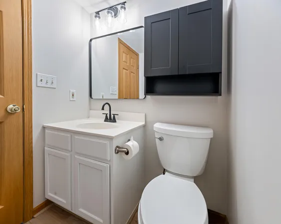 a bathroom with a toilet sink and mirror