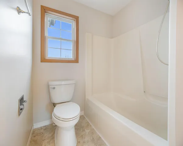 a bathroom with a toilet and a bathtub