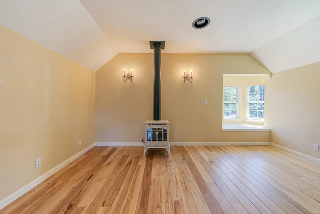 a view of a room with wooden floor and a window