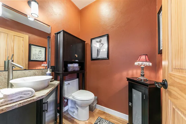 a bathroom with a granite countertop toilet sink and mirror