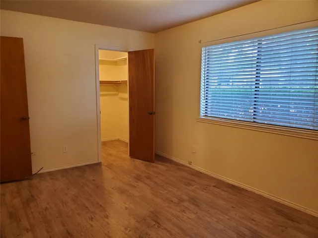 an empty room with wooden floor and a window