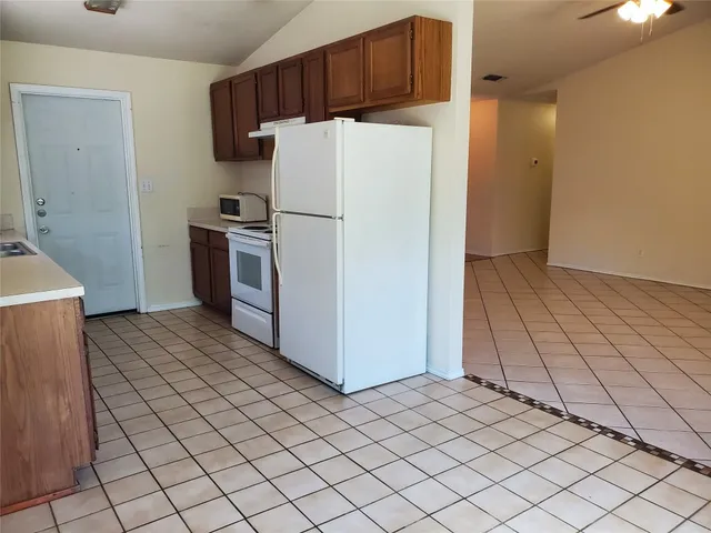 a kitchen with a refrigerator and a stove top oven