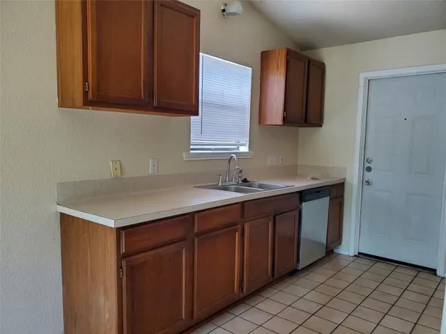 a kitchen with a sink cabinets and a wooden floor