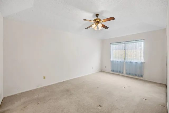 a view of an empty room with a ceiling fan